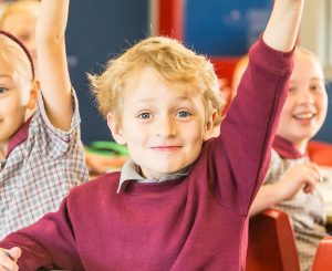 Workplace Giving Sign Up page blog post hero image - children raising hands in class